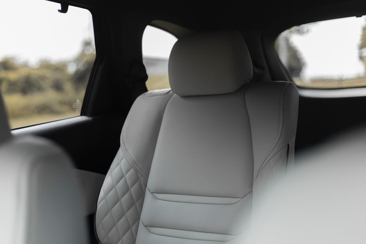 Rear passenger seat inside the vehicle, with a window view